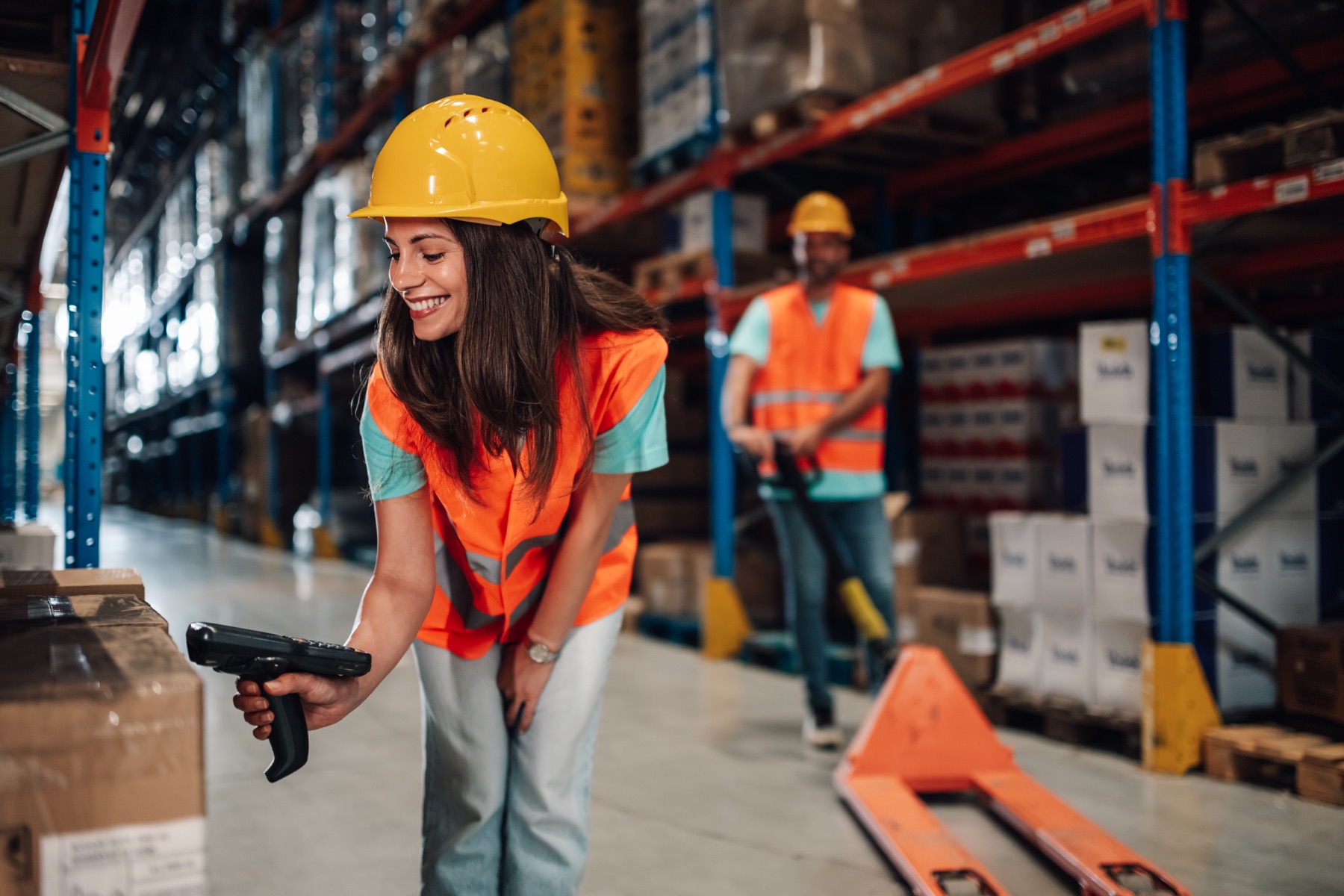 Warehouse worker scanning packages with a handheld mobile scanner
