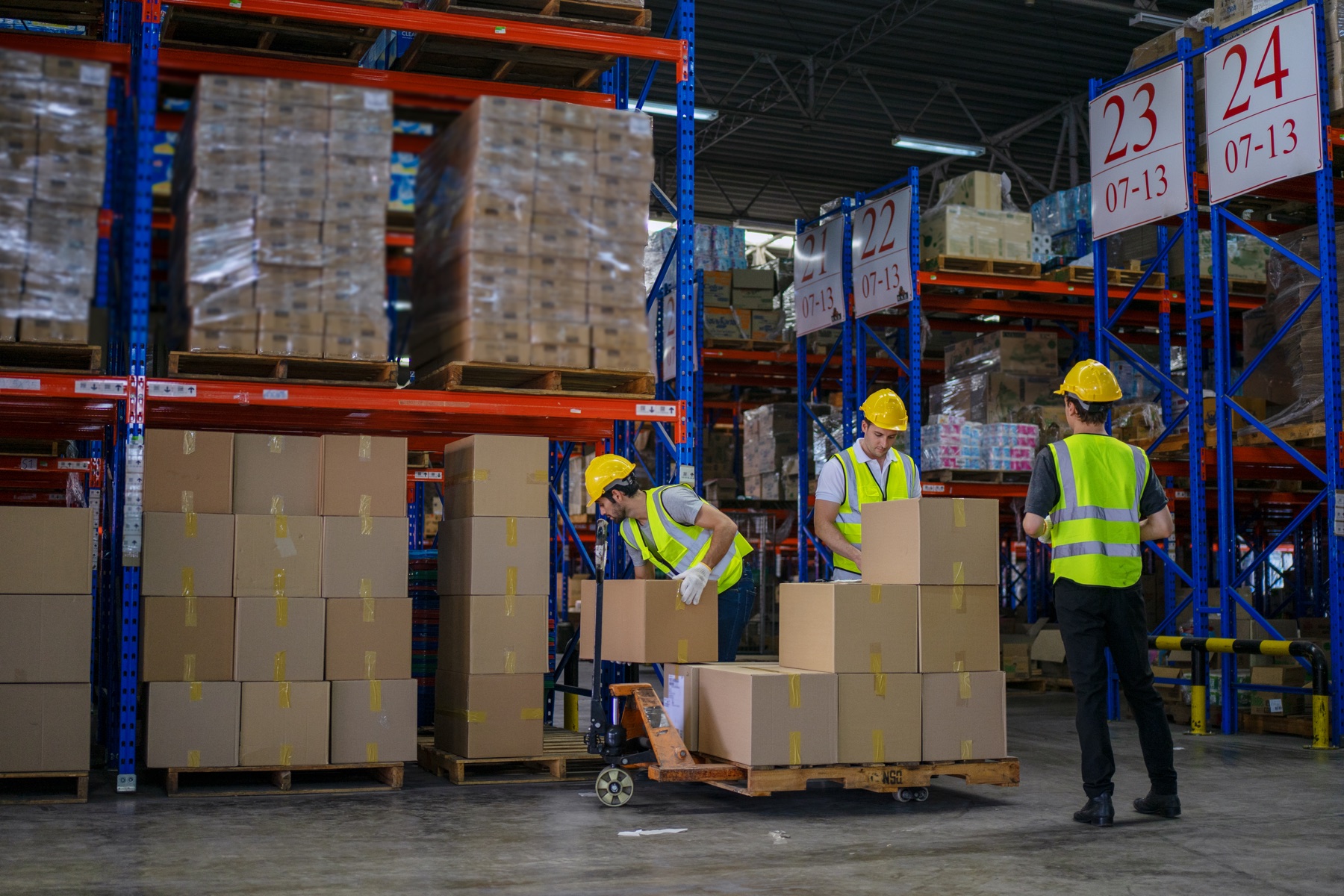 Warehouse workers managing inventory pallets and location signage